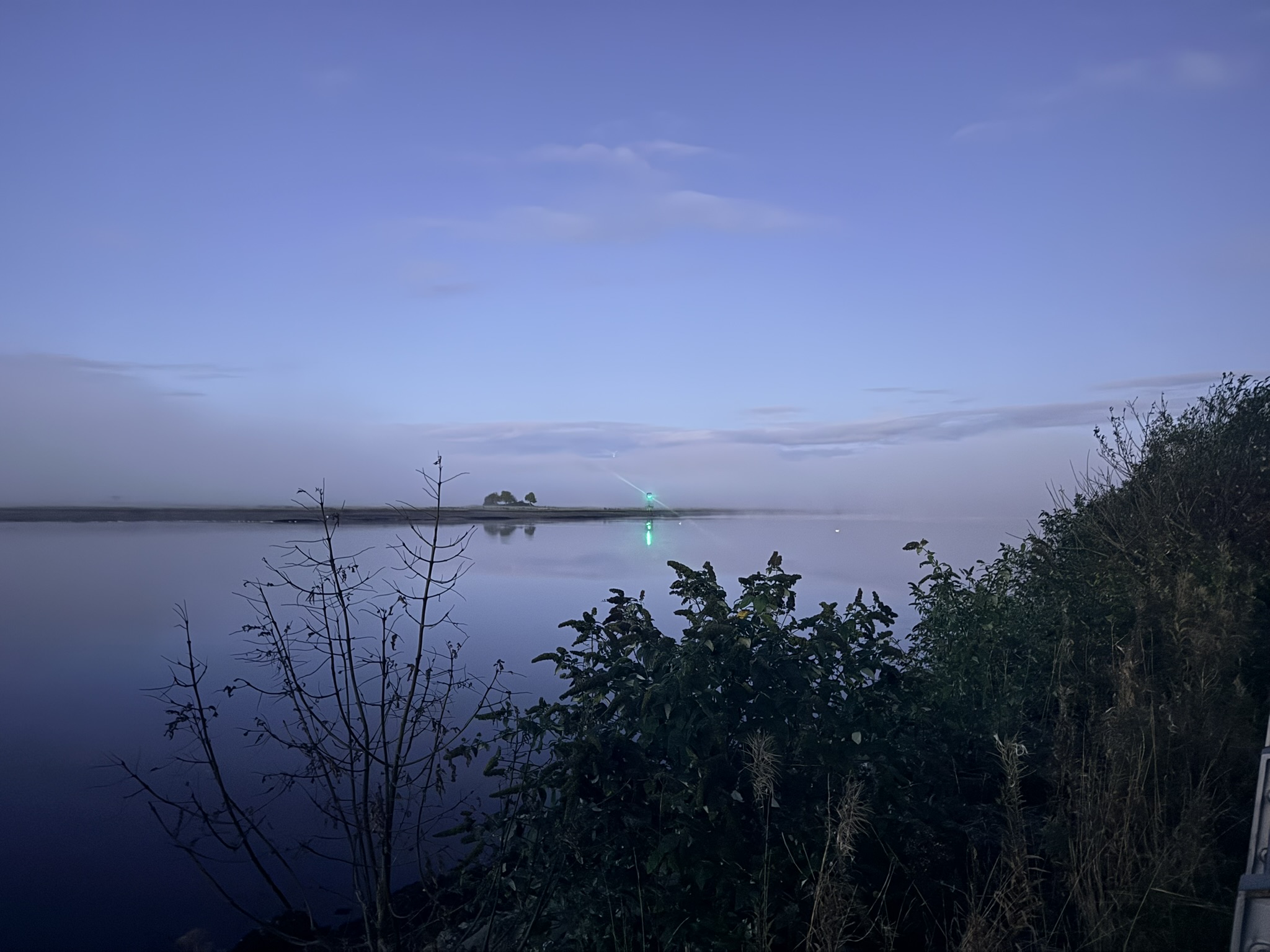 Mist drifting downstream on the Clyde past a green navigation light