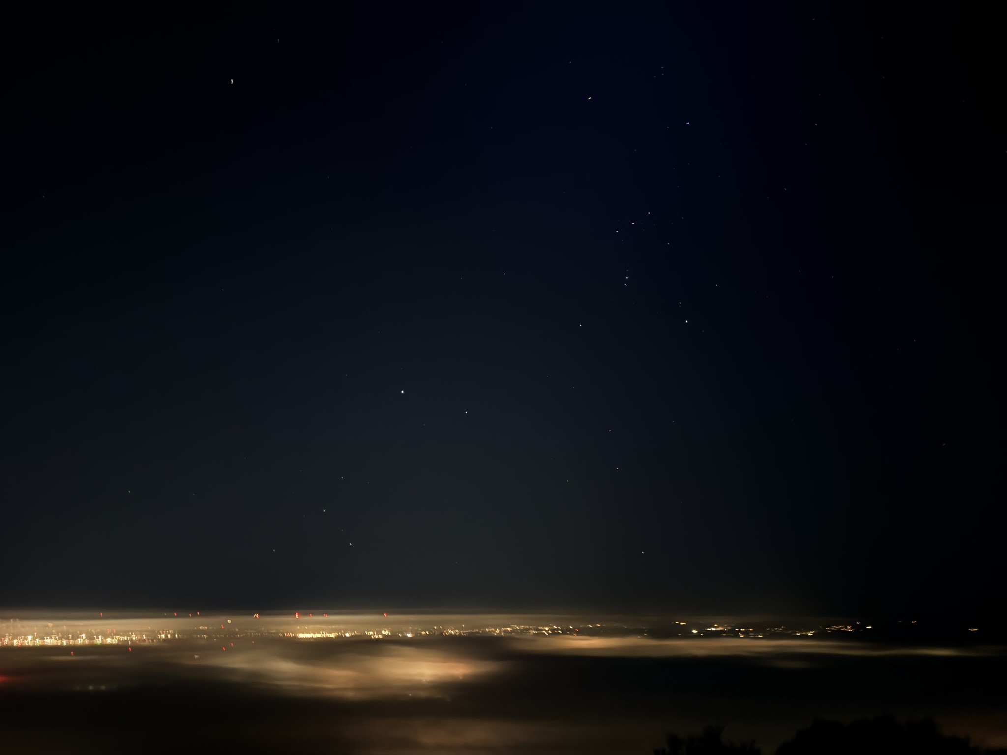 Orion above a cloud-filled valley