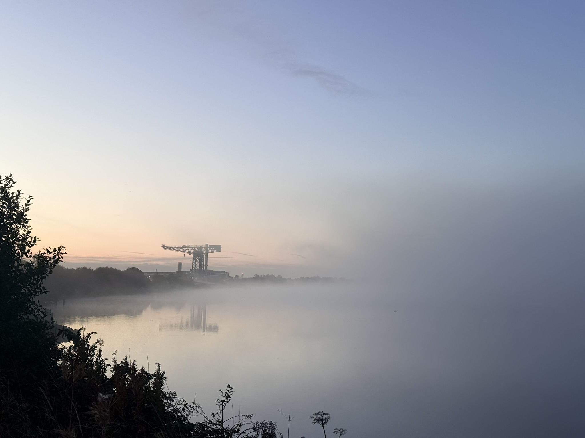 The Titan crane standing clear above a flat layer of mist on the Clyde